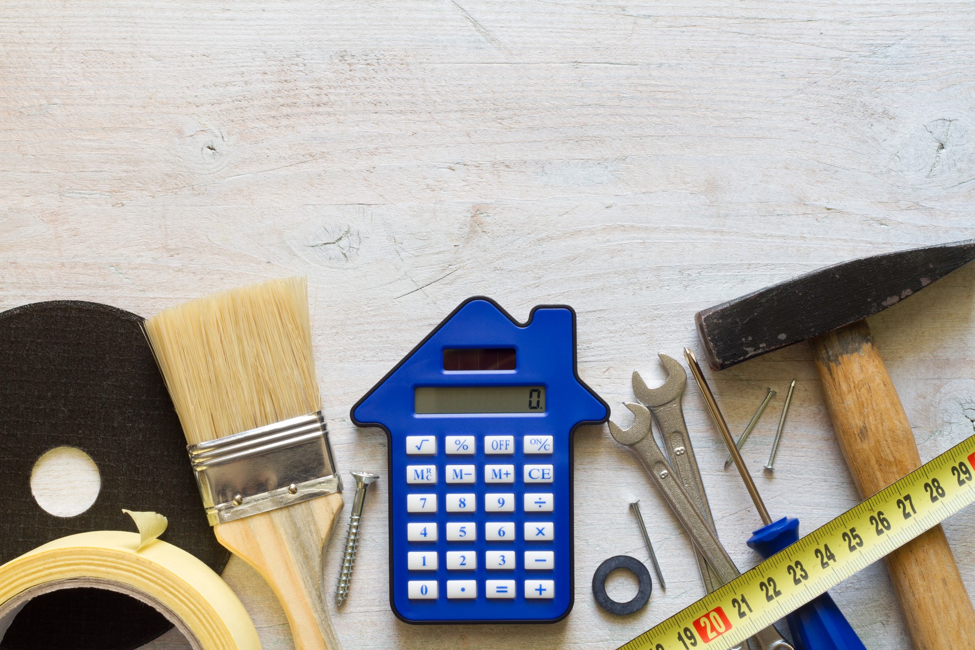 DIY tools and calculator on wooden background, home renovation and construction concept, top view free space