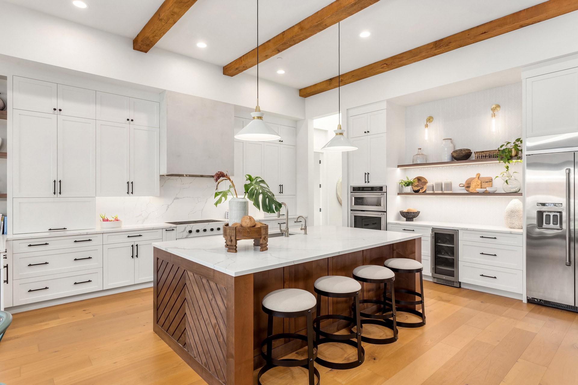 beautiful kitchen in new luxury home with island, pendant lights, and hardwood floors.